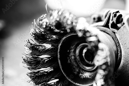 Macro selective focus on the bristle ends of a wire brush wheel on a grinder. photo