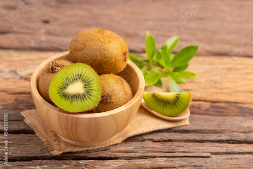 A half of kiwi in a wood bowl on the table