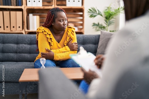 African american women psychologist and patient having mental therapy sitting on sofa at psychology clinic