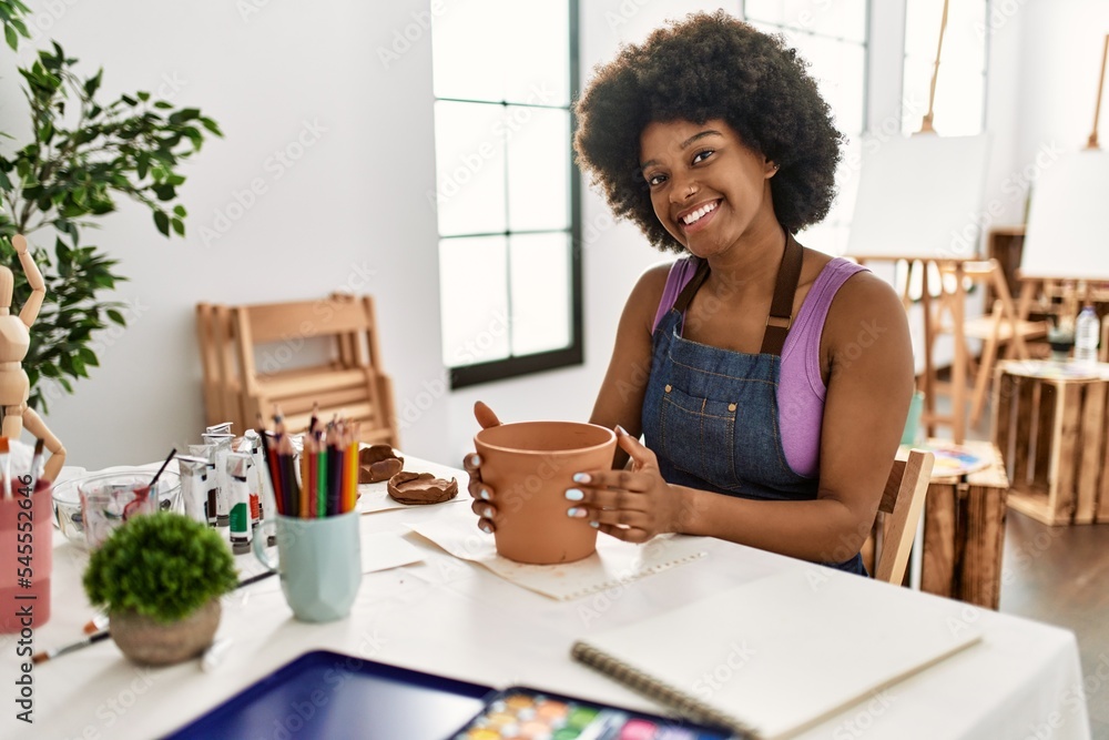 Young african american woman smiling confident making clay pot at art studio Young african american woman smiling confident making clay pot at art studio