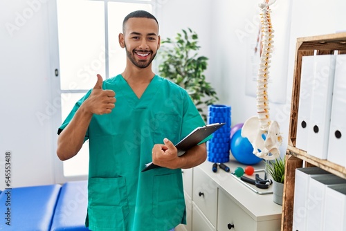 Billede på lærred African american physiotherapist man working at pain recovery clinic doing happy thumbs up gesture with hand