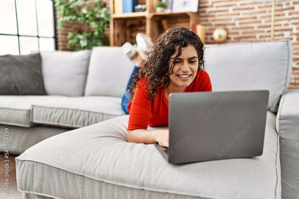 Naklejka premium Young latin woman smiling confident using laptop at home