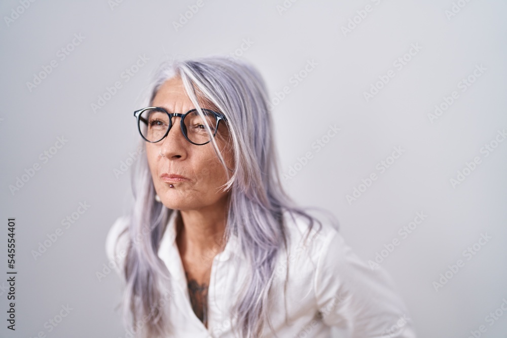 Middle age woman with tattoos wearing glasses standing over white background with hand on stomach because indigestion, painful illness feeling unwell. ache concept.