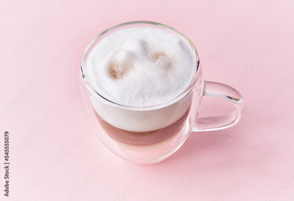 One cup of cappuccino coffee over pink background One cup of cappuccino coffee over pink background