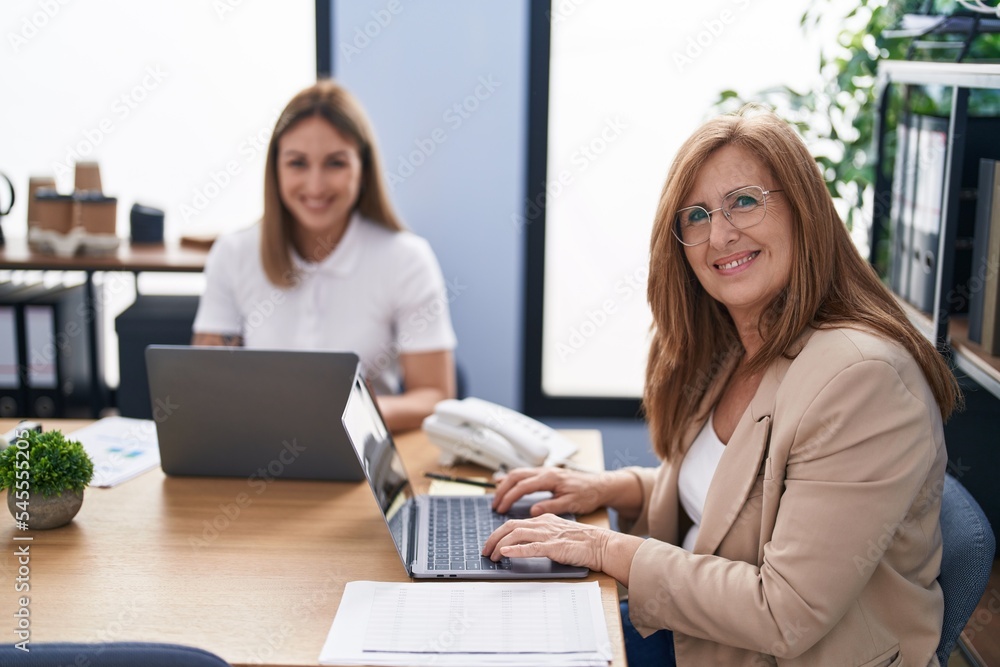 Mother and daughter business workers using laptop working at office Mother and daughter business workers using laptop working at office