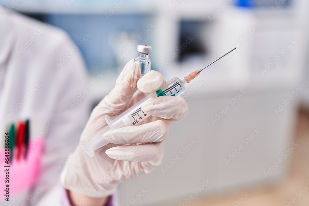 Young caucasian woman scientist wearing holding covid vaccine at laboratory Young caucasian woman scientist wearing holding covid vaccine at laboratory