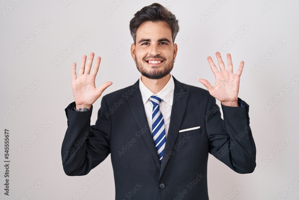 Young hispanic man with tattoos wearing business suit and tie showing and pointing up with fingers number ten while smiling confident and happy. Young hispanic man with tattoos wearing business suit and tie showing and pointing up with fingers number ten while smiling confident and happy.