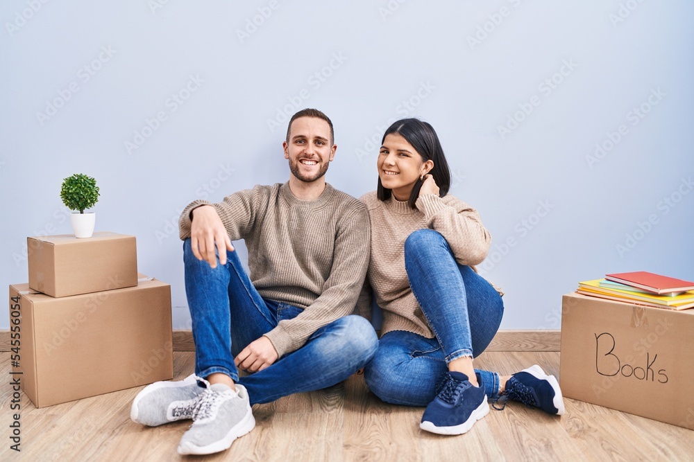 Young couple moving to a new home with a happy and cool smile on face. lucky person. Young couple moving to a new home with a happy and cool smile on face. lucky person.