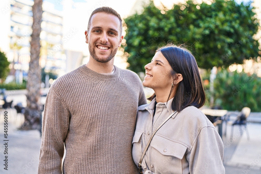 Man and woman couple smiling confident hugging each other standing at street Man and woman couple smiling confident hugging each other standing at street