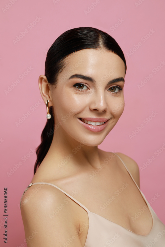 Young woman wearing elegant pearl earrings on pink background Young woman wearing elegant pearl earrings on pink background