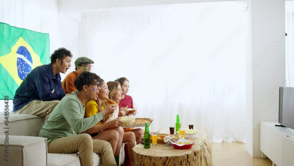 Group of Happy Asian man and woman friends watching world soccer games football competition on television together at home. Sport fans people shouting and celebrating football team victory the match. Group of Happy Asian man and woman friends watching world soccer games football competition on television together at home. Sport fans people shouting and celebrating football team victory the match.