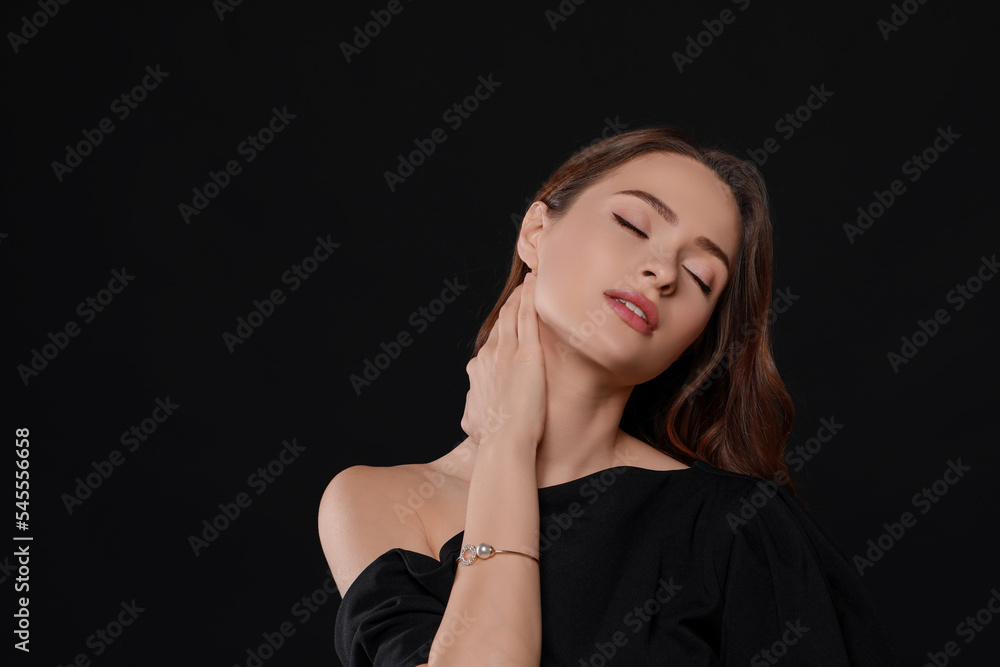 Young woman wearing elegant pearl bracelet on black background, space for text Young woman wearing elegant pearl bracelet on black background, space for text