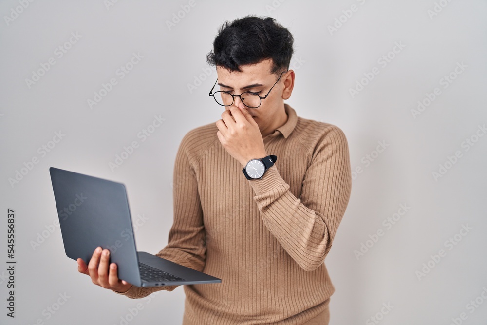Non binary person using computer laptop tired rubbing nose and eyes feeling fatigue and headache. stress and frustration concept. Non binary person using computer laptop tired rubbing nose and eyes feeling fatigue and headache. stress and frustration concept.