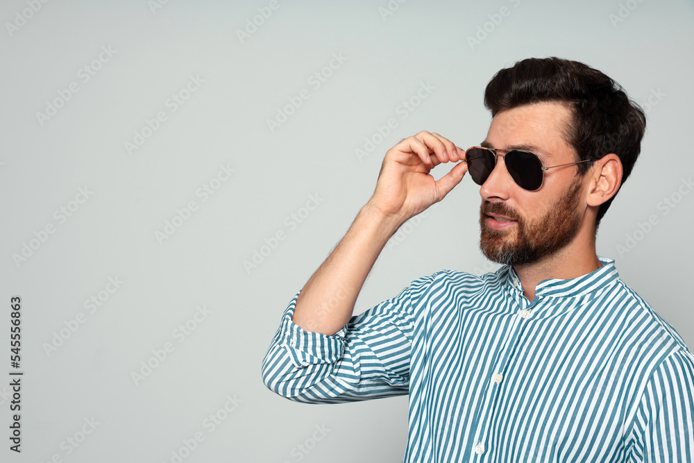 Portrait of bearded man with sunglasses on grey background. Space for text Portrait of bearded man with sunglasses on grey background. Space for text