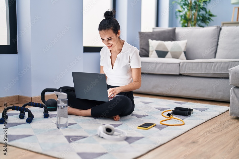 Young caucasian woman sporty using laptop sitting on floor at home Young caucasian woman sporty using laptop sitting on floor at home