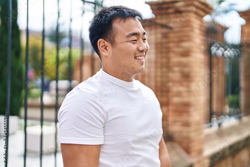 Young chinese man smiling confident standing at street