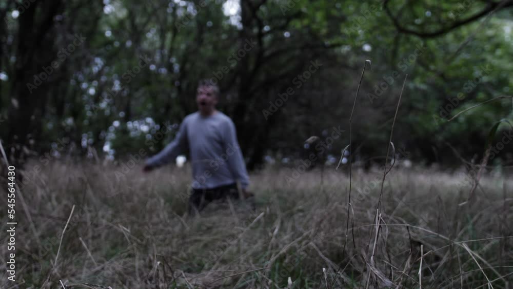 A sad and angry young man falls to his knees in the woods to pray A sad and angry young man falls to his knees in the woods to pray