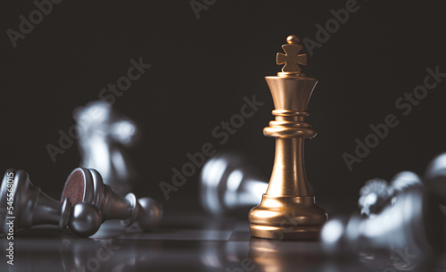 Golden king chess standing among fallen silver chess for winner and defeat after competition   Business strategy concept.