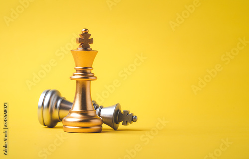 Stand of golden king chess and fallen silver king chess. Winner of business competition and marketing strategy planing concept.