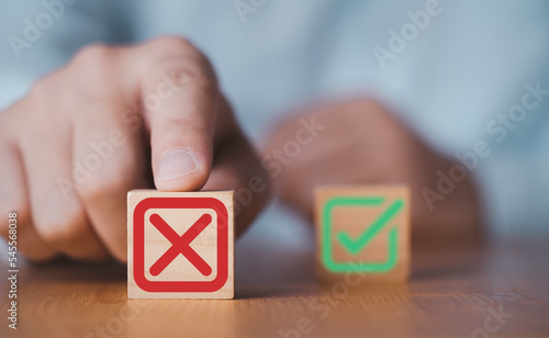 Hand push red Red Cross mark to choose cancellation item , Approve and reject business and document concept. photo