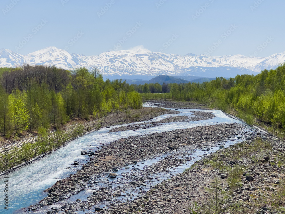 Fototapeta premium Tokachi mountain range and Biei River in early spring