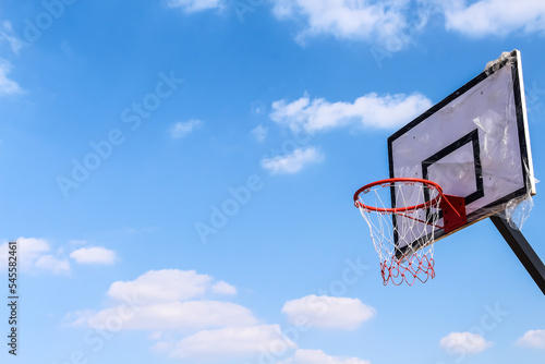 Basketball hoop and net on bright blue sky clouds outdoor background with space © Amphawan