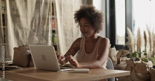 Self employed woman working in own eco shop