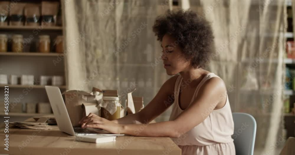 Woman preparing online orders at laptop Woman preparing online orders at laptop