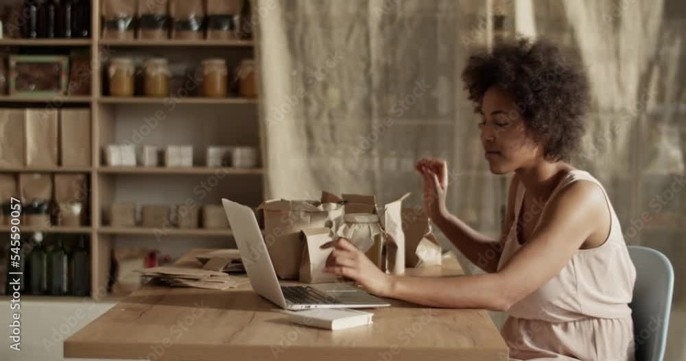 Woman preparing online orders at laptop Woman preparing online orders at laptop