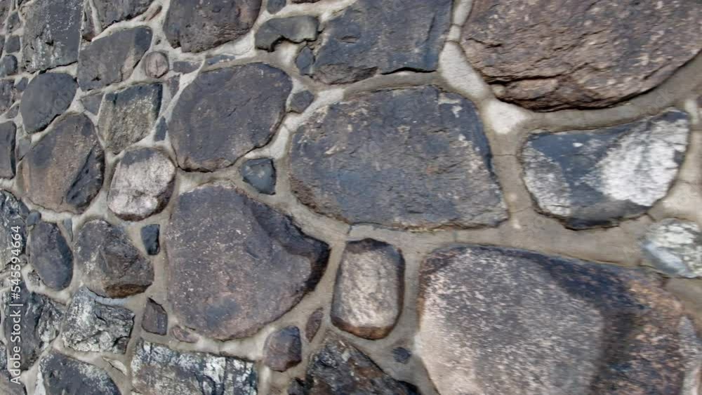 Stone wall made of large rocks and boulders - abstract background and texture of granite or marble retention wall. Stone wall made of large rocks and boulders - abstract background and texture of granite or marble retention wall.