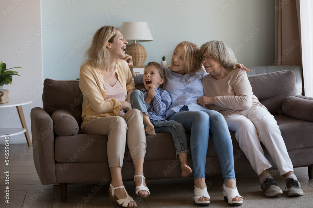 Cheerful four generations of women laughing, enjoy talk and friendly communication, joking sit together on sofa at home feel happy. Warm relationship, offspring, multi-generational family ties, love Cheerful four generations of women laughing, enjoy talk and friendly communication, joking sit together on sofa at home feel happy. Warm relationship, offspring, multi-generational family ties, love