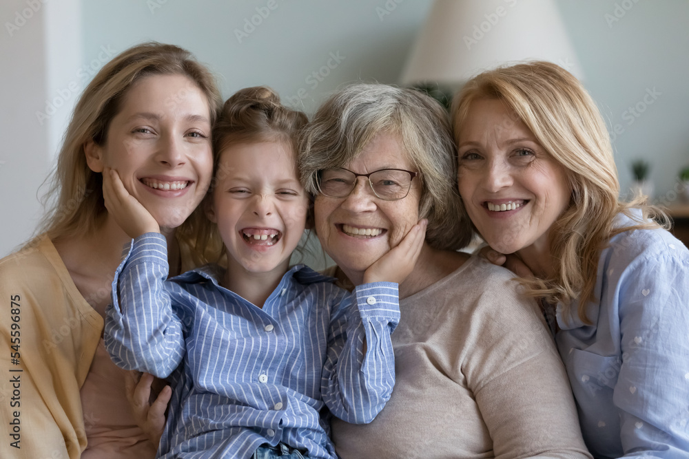 Happy multi generational family portrait, next generation, heredity. Older and younger women posing looking at camera, having wide toothy smile advertise medical insurance, dental care clinic services Happy multi generational family portrait, next generation, heredity. Older and younger women posing looking at camera, having wide toothy smile advertise medical insurance, dental care clinic services