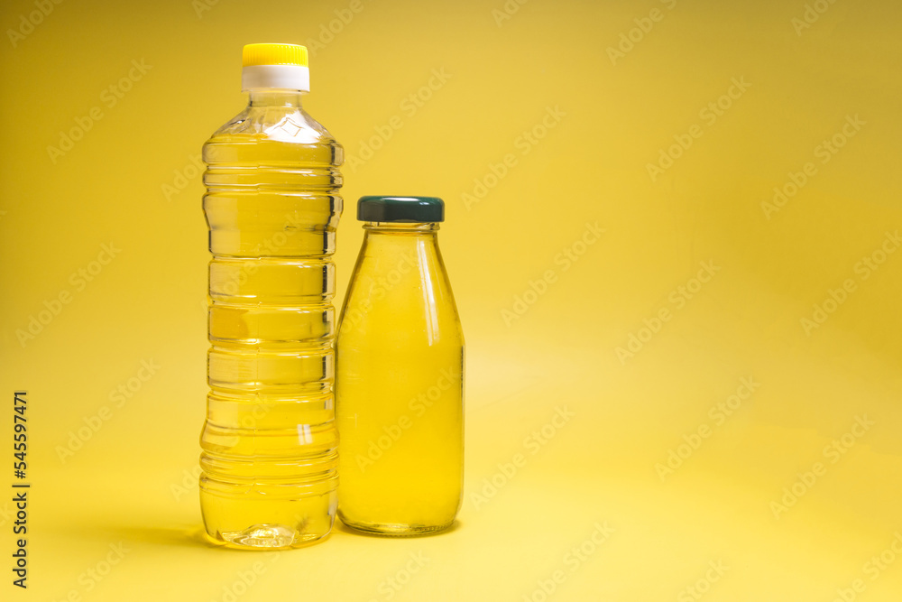 Sunflower oil in transparent bottles close-up on a yellow background copy space Sunflower oil in transparent bottles close-up on a yellow background copy space