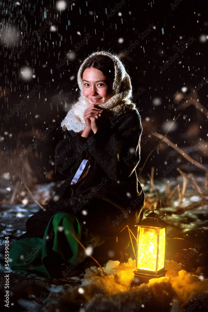 A girl at night in the snow goes in search of a miracle with a lantern. A girl at night in the snow goes in search of a miracle with a lantern.