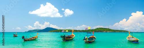 Boats in Rawai beach, Phuket, Thailand. Panoramic view of the beach of Rawai on the island, with traditional long tail fishing boats anchored on the beach. © Jitti