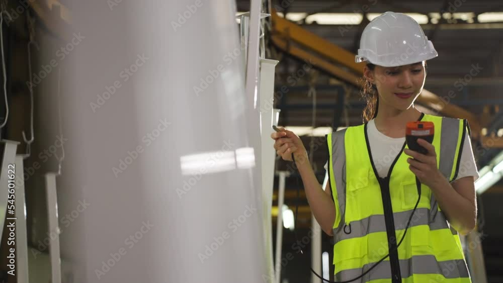 Asian woman metalworker are walking to check the quality of color painting of metal products in a industrial factory Asian woman metalworker are walking to check the quality of color painting of metal products in a industrial factory