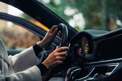 The woman is holding a steering wheel of modern expensive car © Moose