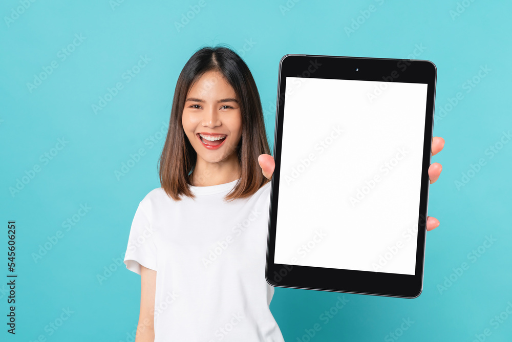 Studio shot of Beautiful Asian woman holding digital tablet mockup of blank screen and smiling on blue background. Studio shot of Beautiful Asian woman holding digital tablet mockup of blank screen and smiling on blue background.