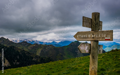 Trail indication signs with snowy mountains in the background near Ayes lake the French Pyrenees mountain range © Pernelle Voyage