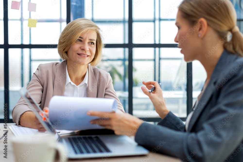 Image of two business women working in the office with documents. Image of two business women working in the office with documents.