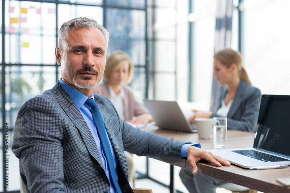 Businessman with colleagues in the background in office. Businessman with colleagues in the background in office.