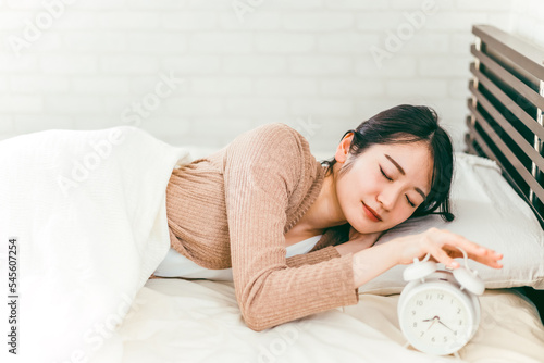 朝ベッドで熟睡して起きれない低血圧の日本人女性
 photo