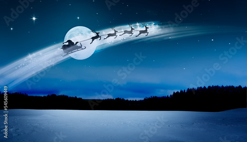 Santa Claus im Schlitten über einer Schneelandschaft bei Nacht