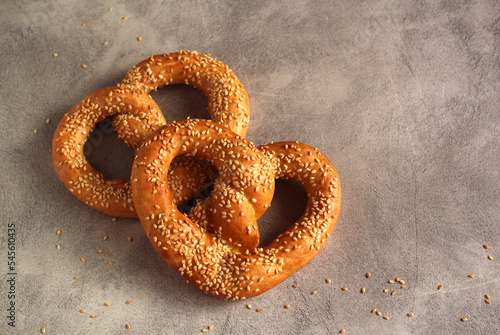 fresh pastries baked kalach in sesame on a gray background