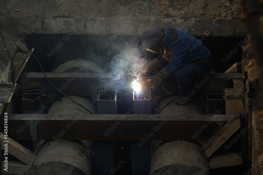 Details with a professional welder welding an industrial metallic pipeline. Details with a professional welder welding an industrial metallic pipeline.