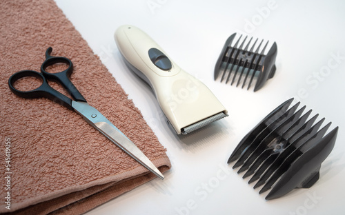 Hairdressing salon.A hair clipper with attachments and scissors on the table. Barber's kit. Hair cutting at the master.