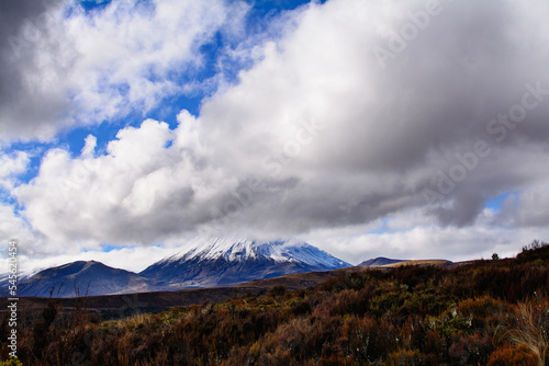Snow blanketed volcanic cone of Mount Ngauruhoe covered by low clouds. Desolated high land field in Central Plateau of New Zealand. Tongariro National Park, North Island