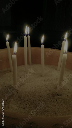 vertical video of candles on a sand ground