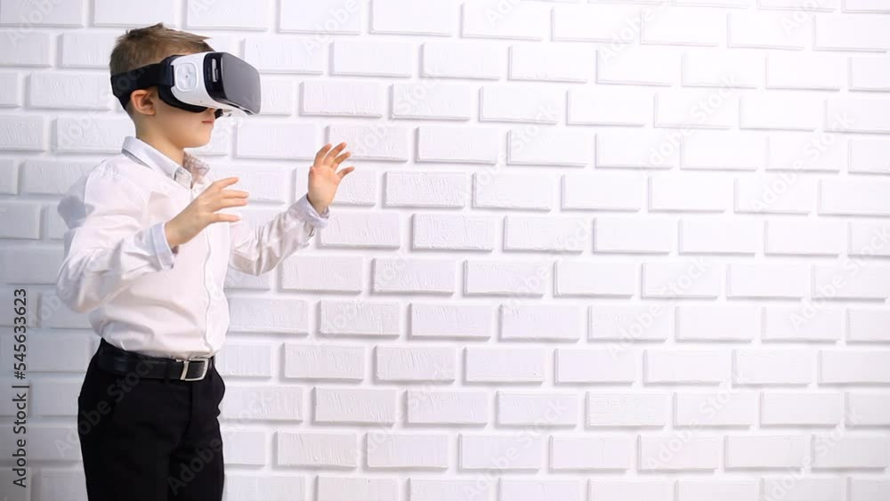 Boy playing games with VR headset. Enjoying time at home. Experiencing virtual reality isolated. Kid wearing VR headset, moving hands and touching air. Digital education or virtual reality learning Boy playing games with VR headset. Enjoying time at home. Experiencing virtual reality isolated. Kid wearing VR headset, moving hands and touching air. Digital education or virtual reality learning