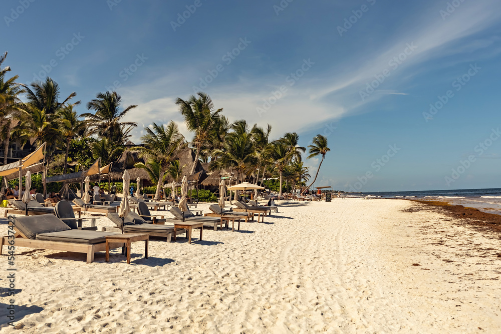 Paradise beach at Tulum, sun umbrellas and sun beds on the beach, Tulum, Mexico